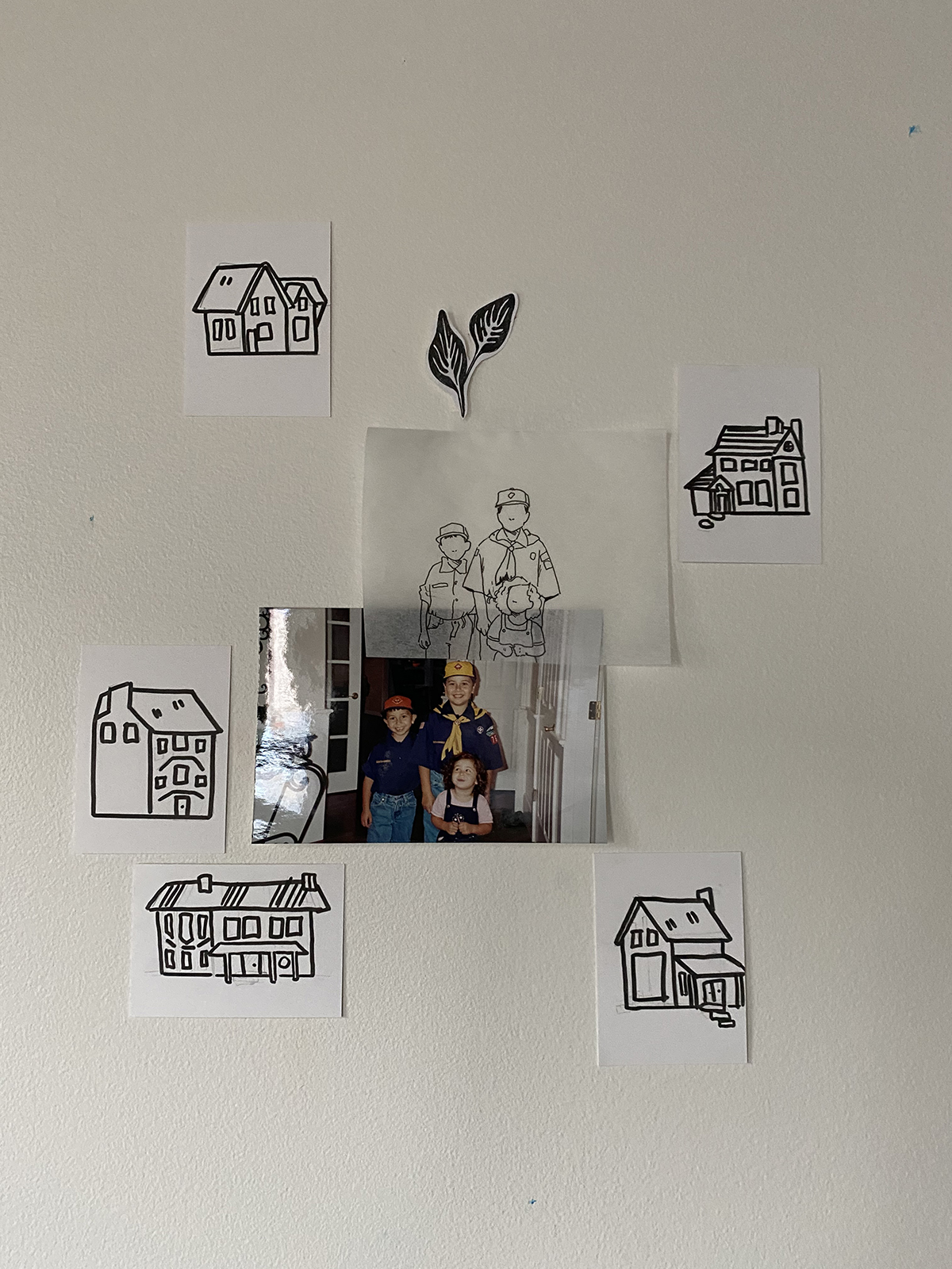 Grouping of drawings and a photograph on a white wall