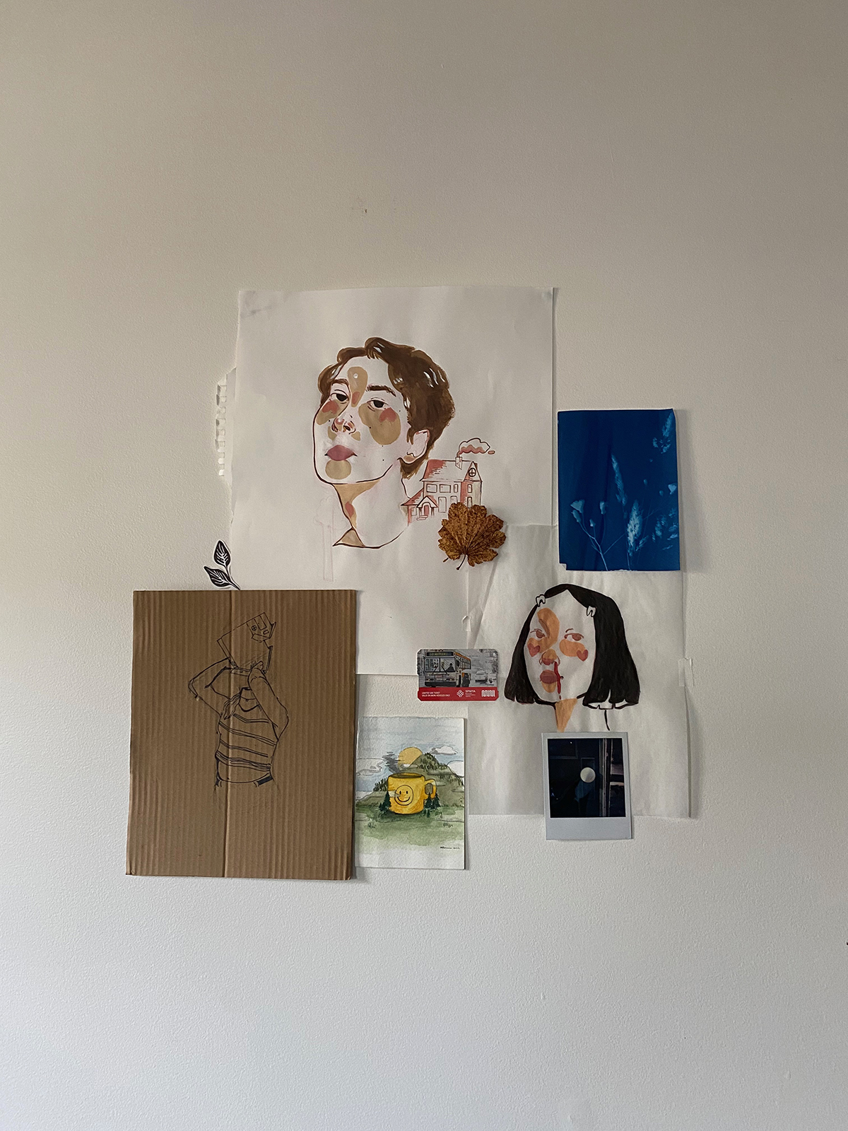 Grouping of drawings and paintings on paper on a white wall