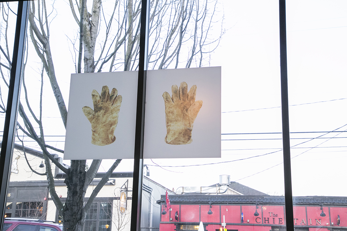 Image of windows with vinyl artwork depicting two large yellow gloves 
