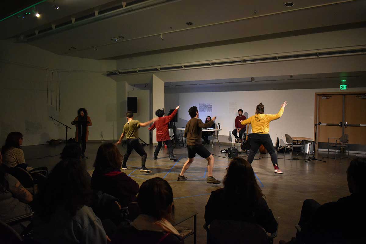 Performers dance in Vachon Gallery with lights and video projections