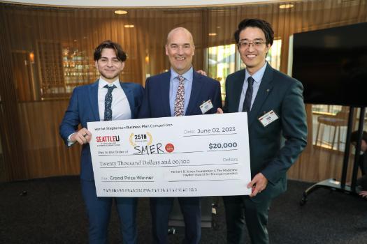Three men in suits holding an oversized check for $20,000 made out to SMER
