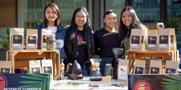 Students at table selling MotMot Coffee on campus