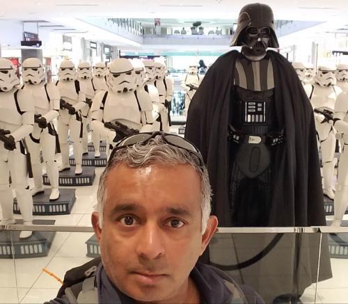 Madhu Rao in foreground against models of Darth Vader and Storm Troopers