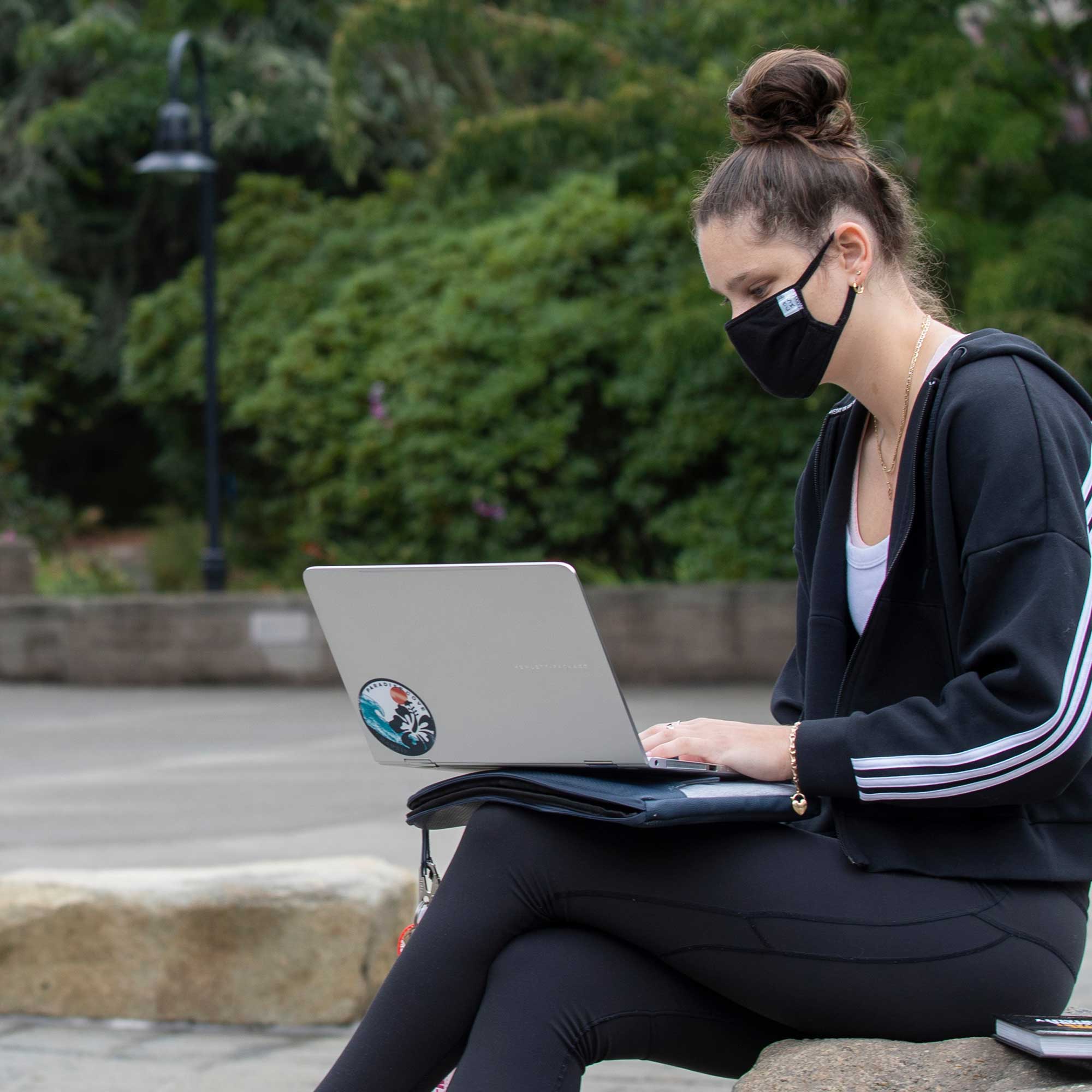 Student working on laptop wearing a mask