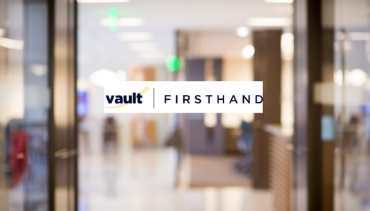 Vault FirstHand logo on blurred office background