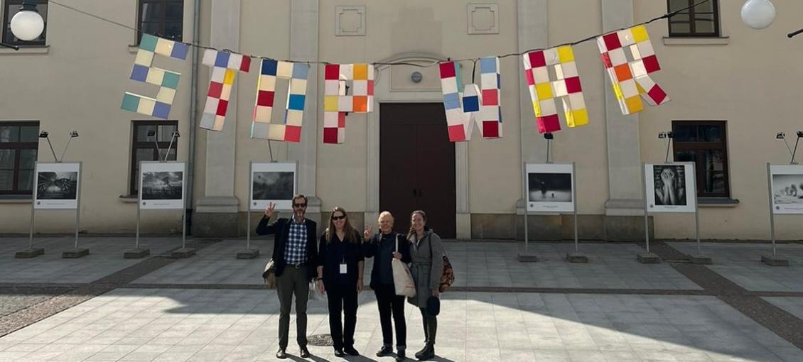 Members of the behavioral health team in Poland standing under colorful flags