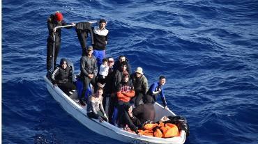 Group of migrants in small boat at sea