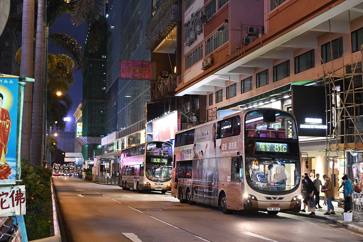 photograph of a double decker bus in a city at night