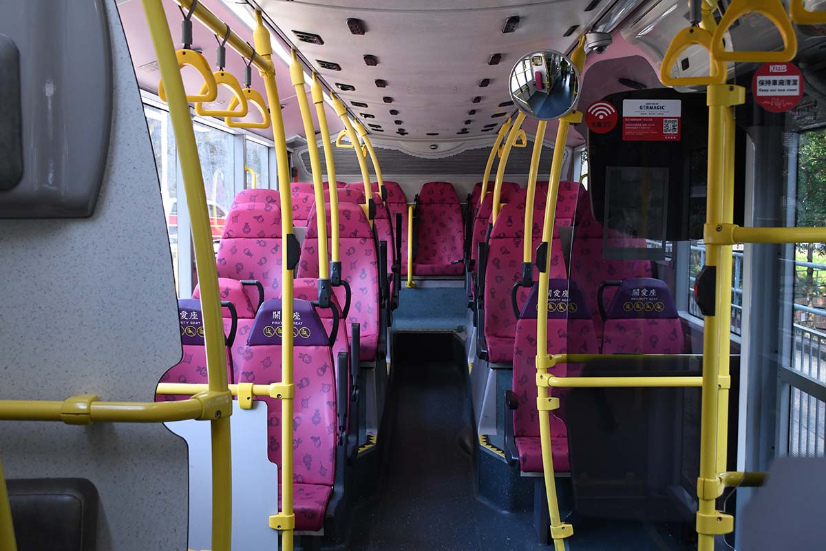 photograph of the interior of a bus looking down the aisle from the front