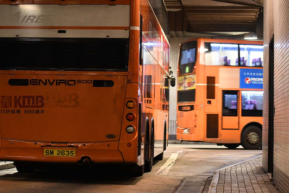 photograph of two busses as one turns a corner