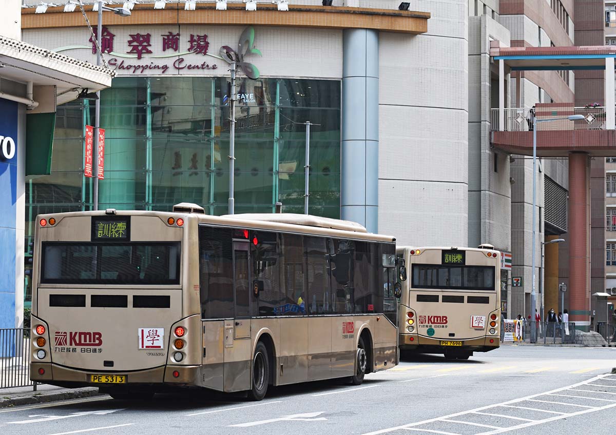 photograph of two busses in a city