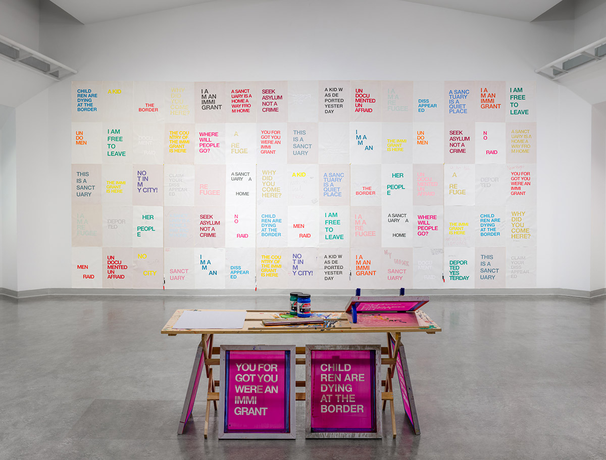 screen print station and wall of posters by Sanctuary City Project installed at Vachon Gallery