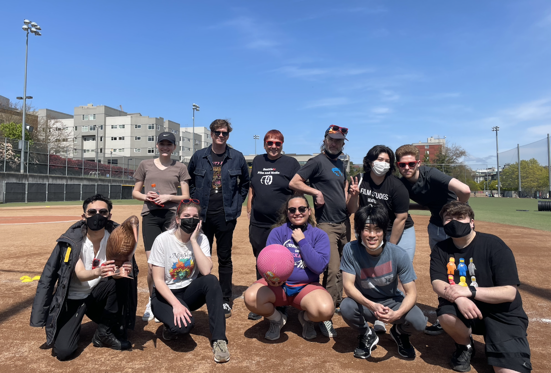 A group of Seattle University Film Studies students grouped together on the field before a kickball game.
