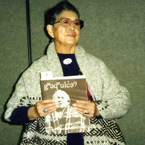 Vi Hilbert holding a book of Lushootseed stories by her Aunt Susie