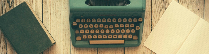 Old green typewriter on weather-worn desk