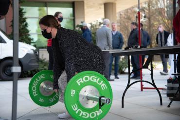 Student deadlifting in front of Mobile Lab