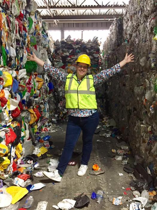 Jessie Dirks at the Cascade Recycling Center surrounded by recycling.