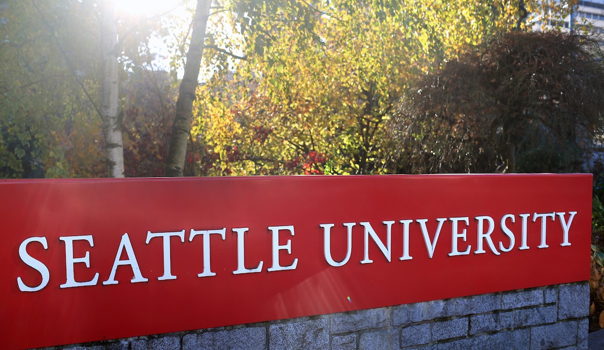 Seattle U campus sign in dappled sunlight