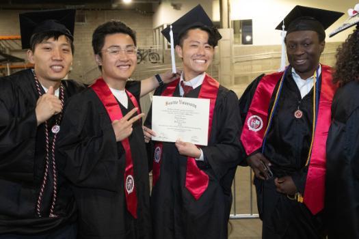 A group of four students with degrees backstage.