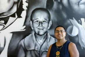 Artist Andrew Morrison standing next to his mural
