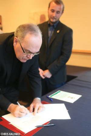 President Sundborg, S.J., signs the agreement to establish SU as a Fair Trade university