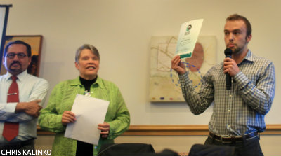 Parker Townley, a representative from Fair Trade Colleges and Universities, presents a Fair Trade University certificate