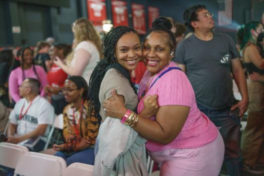 student and parent embrace in pink at kickoff event