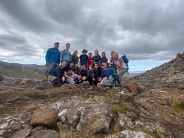 A group of people posing on rocky land.