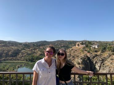 Two people standing in front of a view of landscape