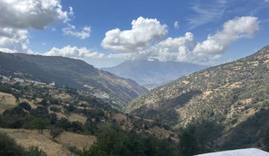 view of a mountain range with a small town in the valley of 4 mountains
