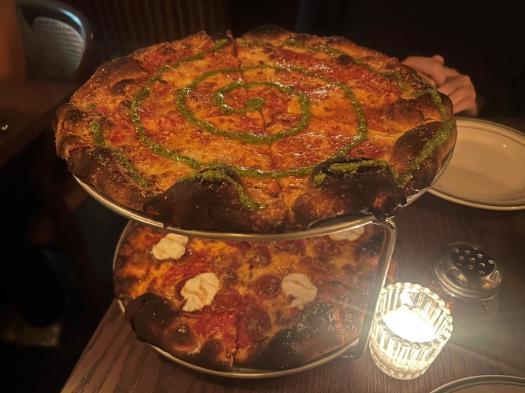 2 pizza pies on a pie rack