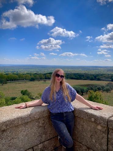 Person posing in front of grassy landscape