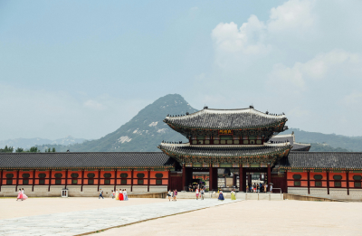 red and black palace entrance with mountains behind during the daytime