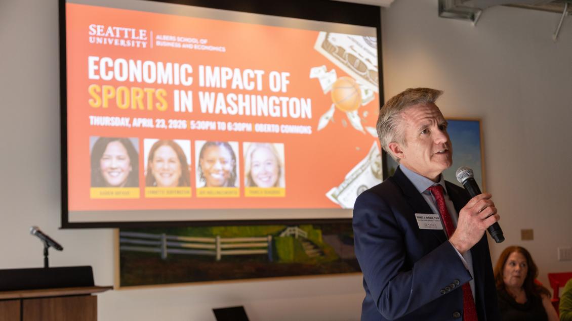 Dean Turner in front of a projected slide titled