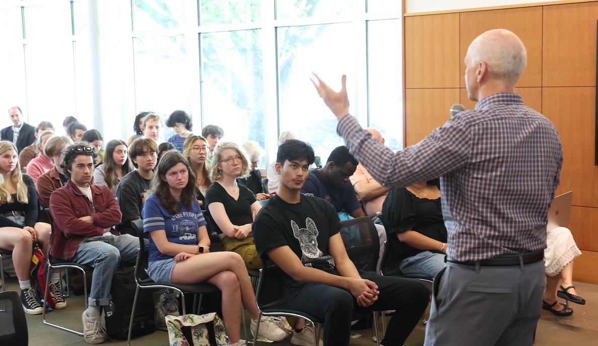 Adam Smith talking to students side profile
