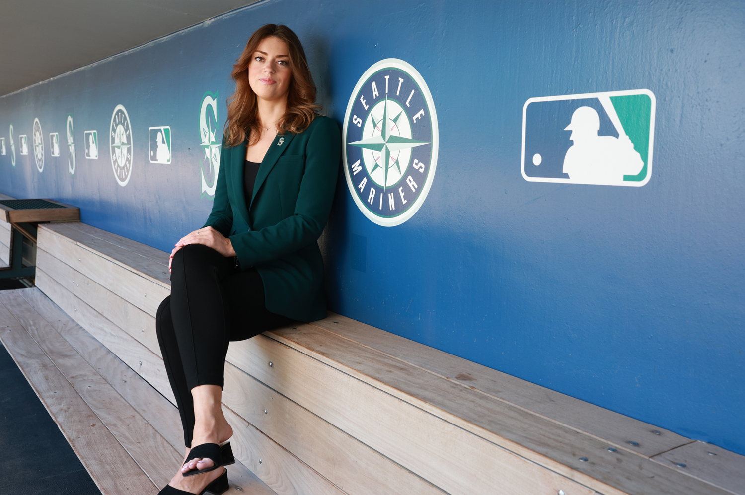A portrait of Liz Sword sitting in the Mariners dugout