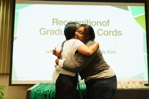 Image of Michelle Kim hugging Lynia Morris at GSOCC