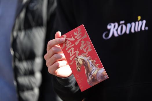 An image of someone holding a red envelope used to celebrate Lunar New Year