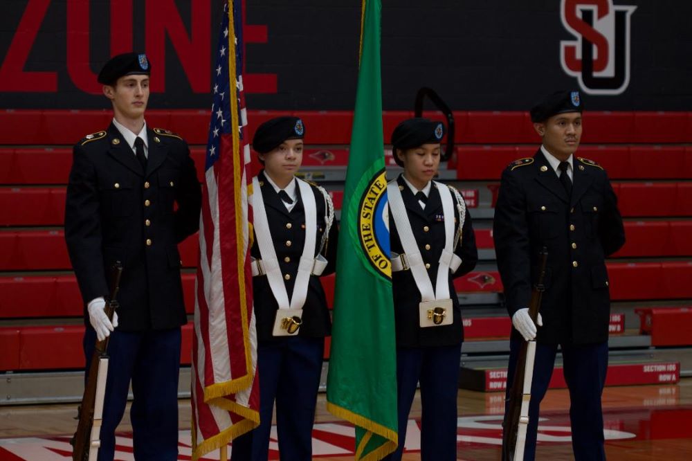 Four Cadets in dress uniform w/ flags