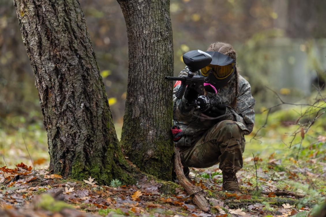 Cadet in geat paintball outdoor behind tree