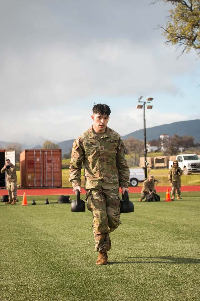 Cadet in Army greens carry weights outside