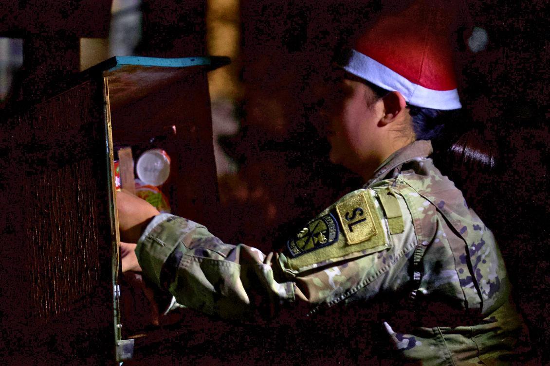 Cadet putting food into food bin