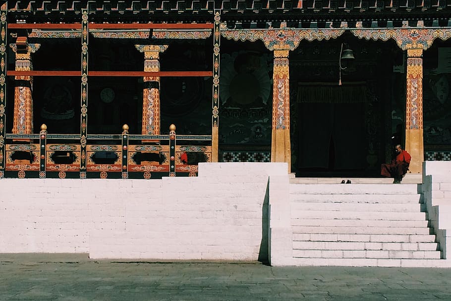 Monk sitting at the steps of a temple
