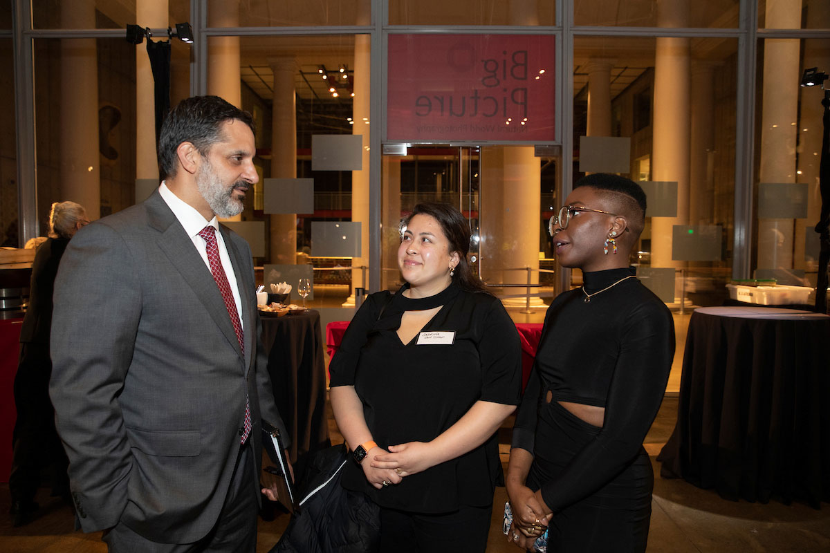 President Peñalver speaking with two event attendees.
