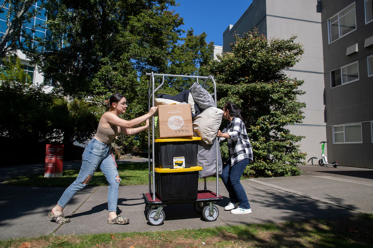 Students moving into the dorms, walking their wares across campus.