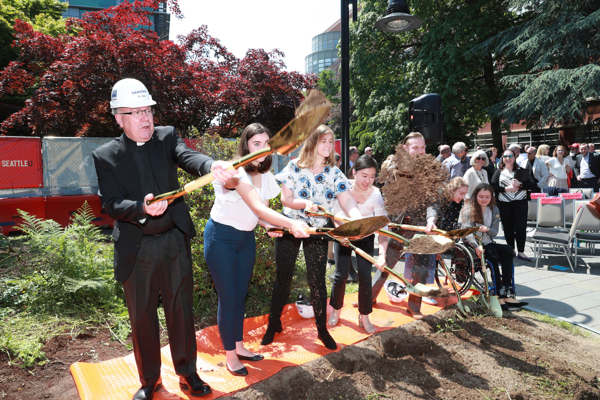 Father Steve and students, with shovels, break ground on the new CSI building