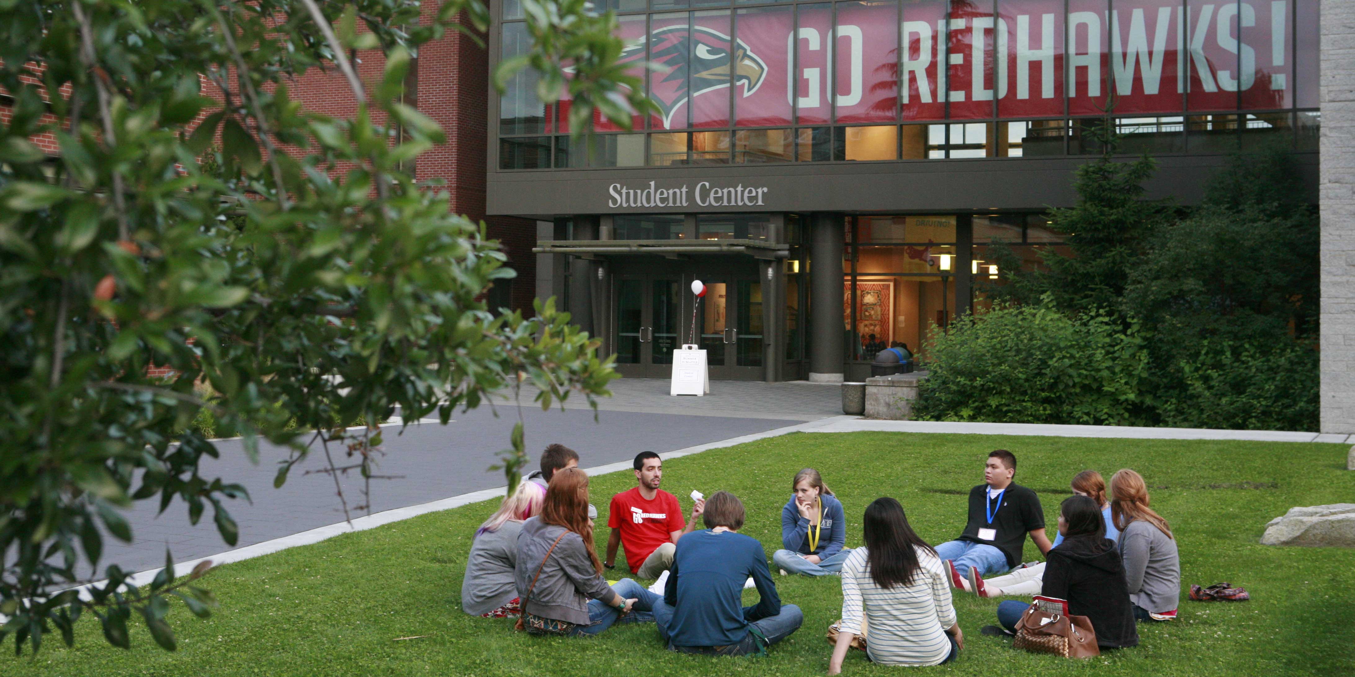 New students at summer orientation sitting in the grass outside the Student Center