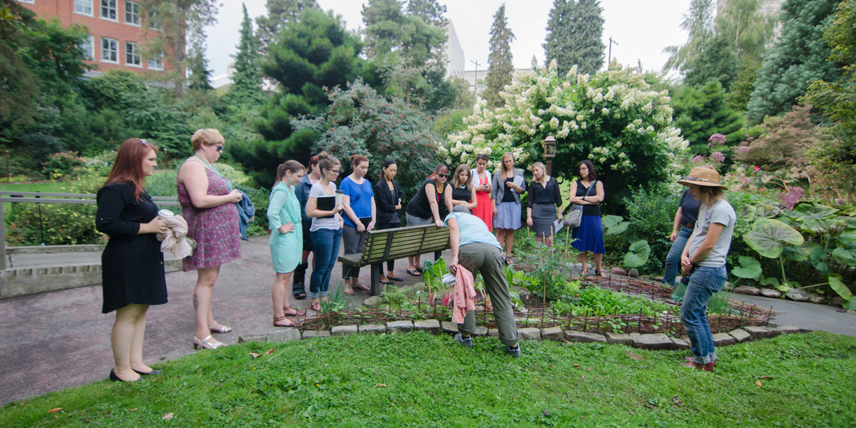 a crowd of people on a tour of edible plants on campus