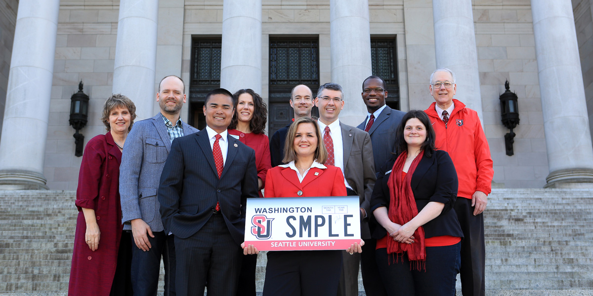 Government officials and Seattle U representatives holding the new Seattle U License plate after its approval