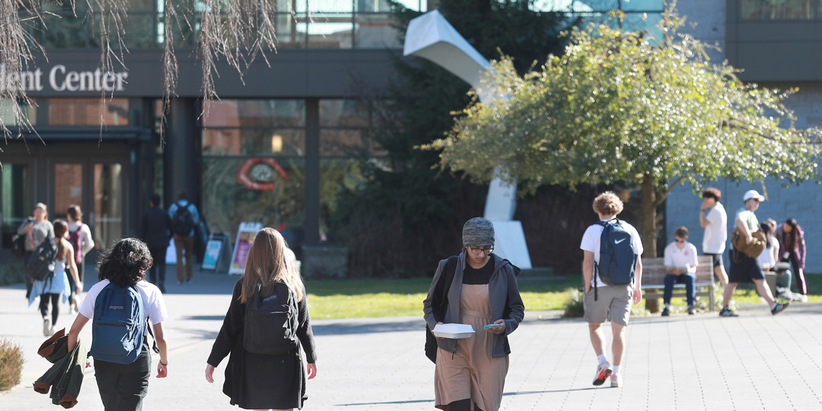 Students walking near the Student Center with Loo Wit sculpture in the background